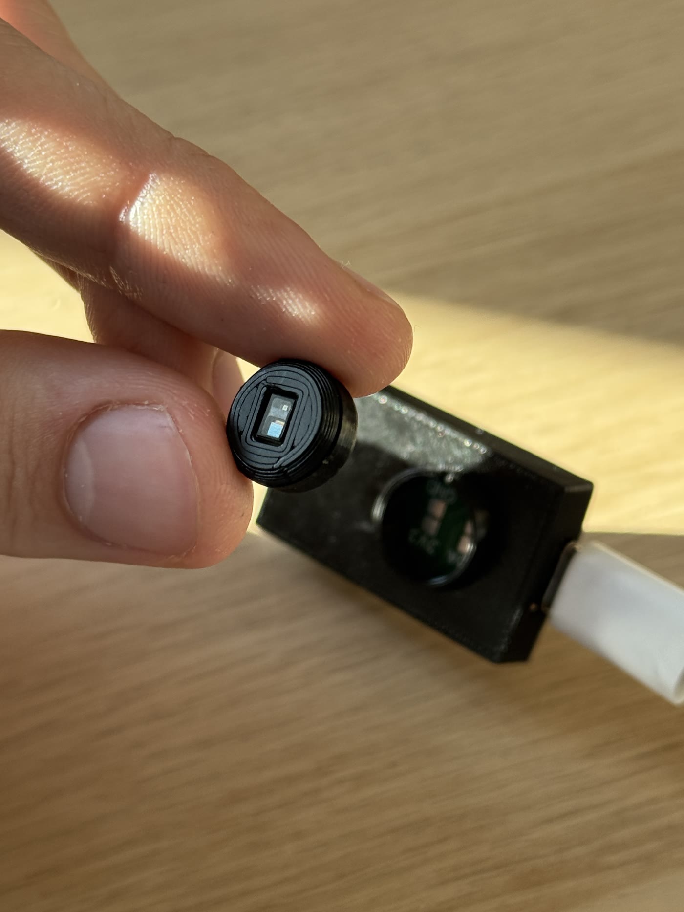A hand holding the removable optical sensor puck from an OpenPulse prototype