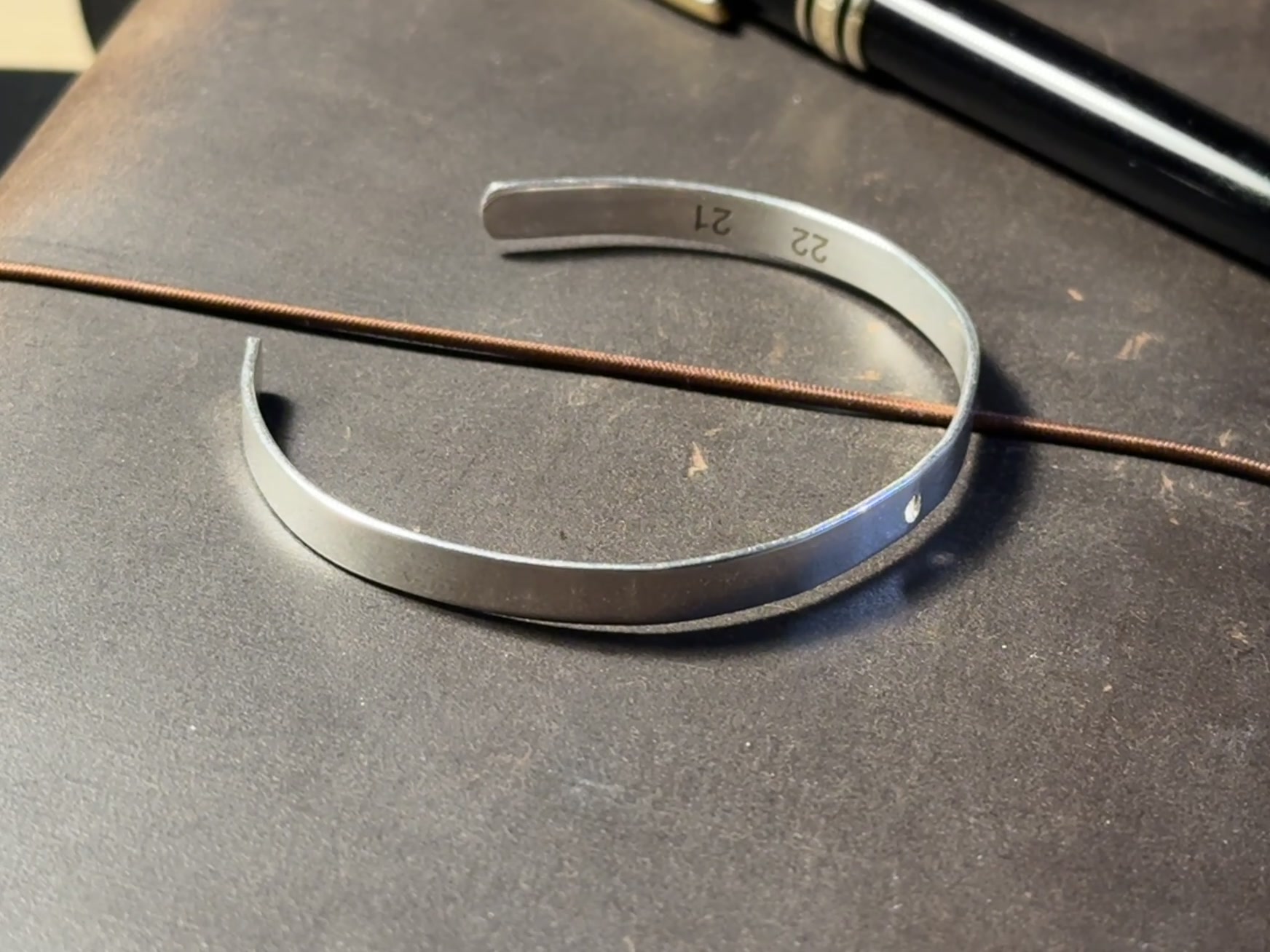 The curved metal band of Mateo's wearable sundial during fabrication